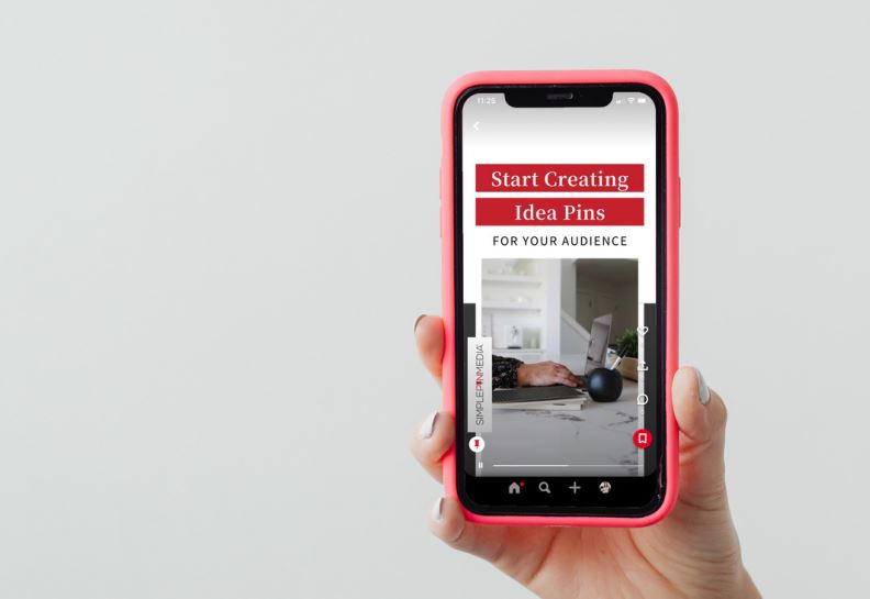 hand holding red iphone with text "start creating idea pins for your audience".