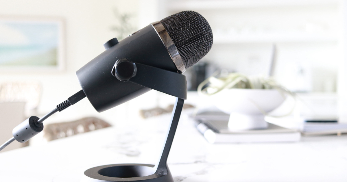 A black podcast microphone sitting on a desk.