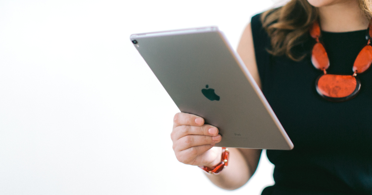 A woman's hand holding an iPad.