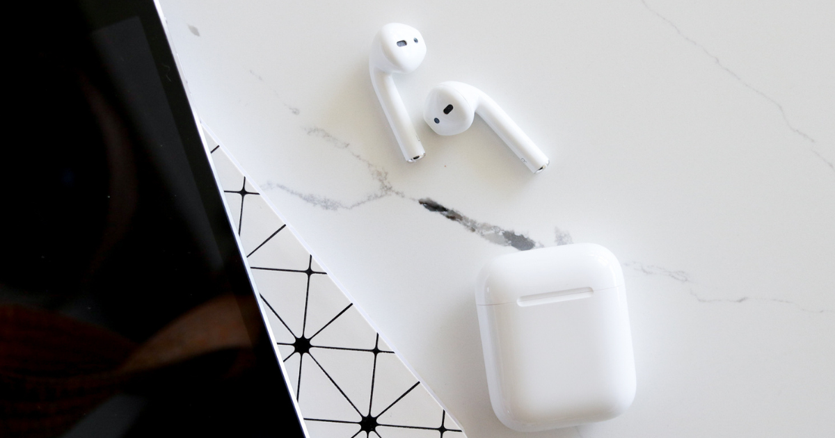 A pair of airpods sitting on a desk.