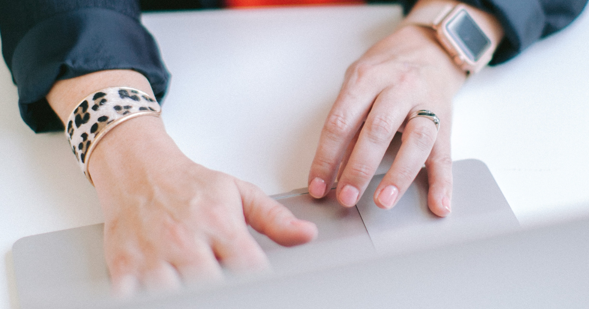 Woman's hands typing on a laptop.